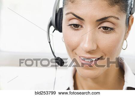 Stock Photo - Mixed Race businesswoman wearing telephone headset. Fotosearch