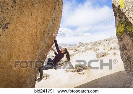 Stock Image - Mixed Race girl climbing rock. Fotosearch