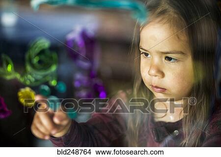 Mixed race girl finger painting on window View Large Photo Image Picture - Mixed race girl finger painting on window. Fotosearch