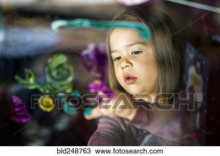 Mixed race girl finger painting on window View Large Photo Image Stock Image - Mixed race girl finger painting on window. Fotosearch