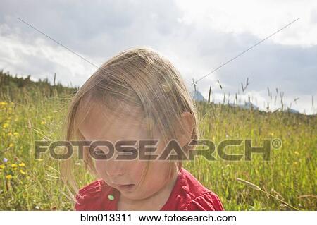 Stock Image - Mixed race girl standing in field. Fotosearch