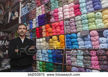 Stock Photography - Mixed Race man posing at yarn store. Fotosearch