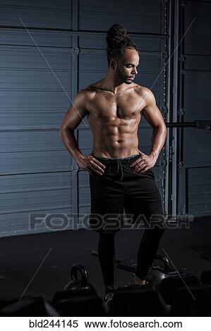Stock Photography - Mixed Race man resting in gymnasium. Fotosearch