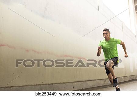 Stock Photo - Mixed Race man running near wall. Fotosearch