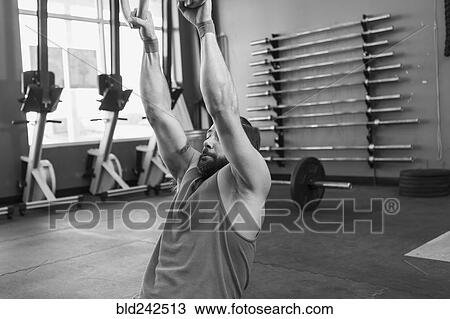 Mixed Race man working out with rings in gymnasium View Large Photo Image Stock Image - Mixed Race man working out with rings in gymnasium. Fotosearch