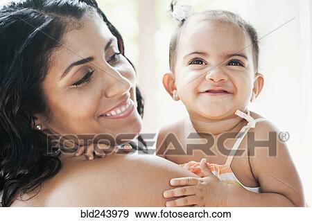 Stock Photo - Mixed Race mother holding baby daughter. Fotosearch
