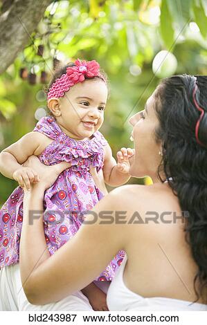 Mixed Race mother playing with baby daughter View Large Photo Image Stock Photo - Mixed Race mother playing with baby daughter. Fotosearch