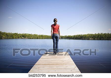 Mixed Race woman at the edge of dock at lake View Large Photo Image Stock Photography - Mixed Race woman at the edge of dock at lake. Fotosearch