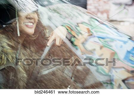 Mixed Race woman behind windshield driving car View Large Photo Image Stock Image - Mixed Race woman behind windshield driving car. Fotosearch