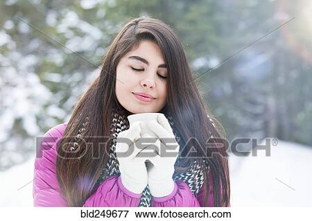 Mixed Race woman enjoying warm beverage in winter View Large Photo Image Stock Photo - Mixed Race woman enjoying warm beverage in winter. Fotosearch