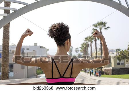 Stock Photo - Mixed Race woman flexing arms. Fotosearch
