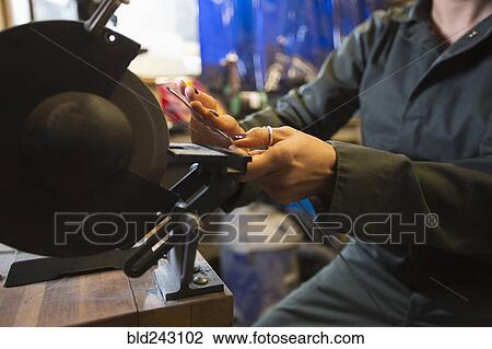 Mixed Race woman grinding metal rod in workshop View Large Photo Image Stock Image - Mixed Race woman grinding metal rod in workshop. Fotosearch