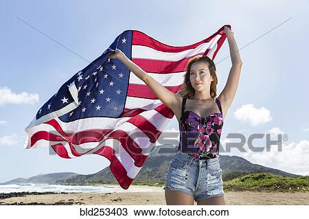 Mixed Race woman holding American flag on beach View Large Photo Image Stock Image - Mixed Race woman holding American flag on beach. Fotosearch