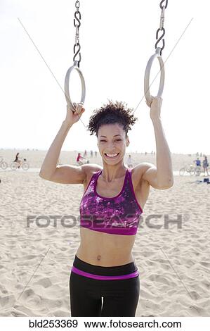 Mixed Race woman holding gymnastics rings at beach View Large Photo Image Stock Photo - Mixed Race woman holding gymnastics rings at beach. Fotosearch
