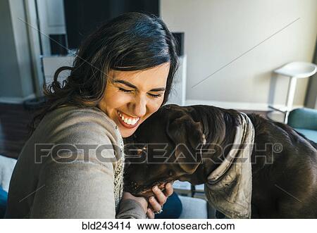 Picture - Mixed Race woman hugging dog. Fotosearch