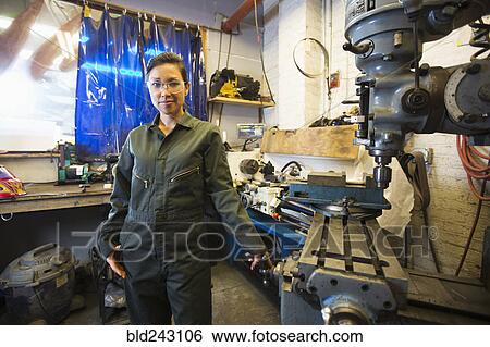 Mixed Race woman posing near machinery in workshop View Large Photo Image Stock Photograph - Mixed Race woman posing near machinery in workshop. Fotosearch