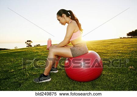 Mixed Race woman resting on fitness ball in sunny field View Large Photo Image Stock Photography - Mixed Race woman resting on fitness ball in sunny field. Fotosearch