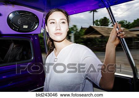 Stock Photograph - "Mixed Race woman riding bus in Bangkok, Thailand". Fotosearch