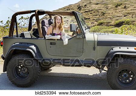 Picture - Mixed Race woman sitting in convertible car. Fotosearch