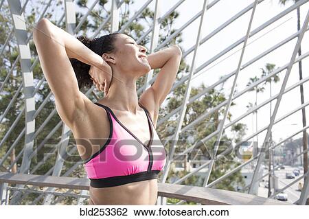 Stock Image - Mixed Race woman stretching arms. Fotosearch