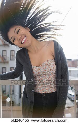 Mixed Race woman tossing hair on rooftop View Large Photo Image Stock Photography - Mixed Race woman tossing hair on rooftop. Fotosearch