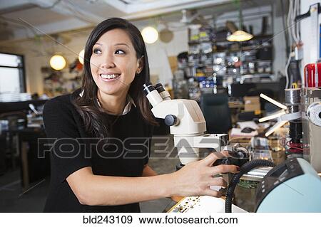 Mixed Race woman using microscope View Large Photo Image Stock Photo - Mixed Race woman using microscope. Fotosearch