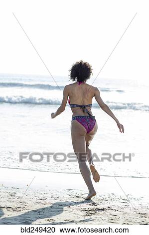 Mixed Race woman wearing bikini running to ocean View Large Photo Image Stock Image - Mixed Race woman wearing bikini running to ocean. Fotosearch