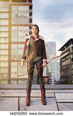 Mixed race woman with bow and arrow on urban rooftop View Large Photo Image Stock Image - Mixed race woman with bow and arrow on urban rooftop. Fotosearch