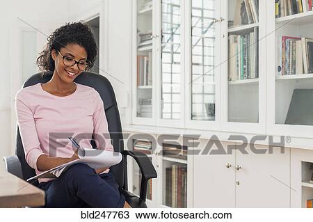 Mixed Race woman writing on notepad View Large Photo Image Stock Image - Mixed Race woman writing on notepad. Fotosearch