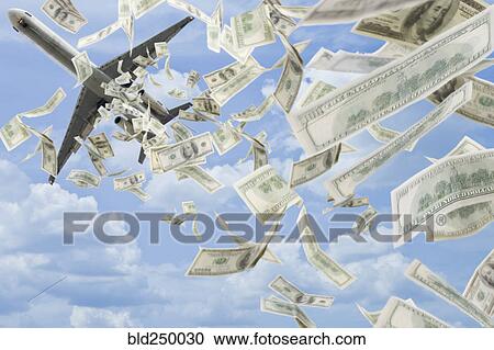 Stock Image - Money falling in sky under airplane. Fotosearch