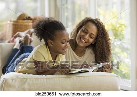 Stock Image - Mother and daughter reading book. Fotosearch
