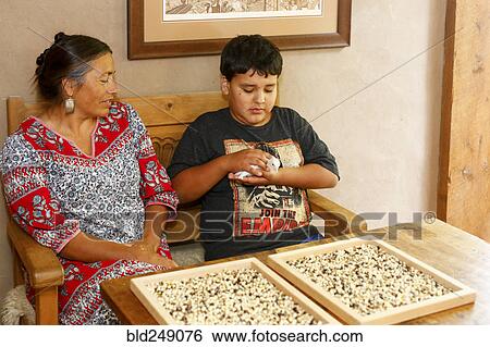 Stock Photograph - Mother and son admiring baby turkey at table. Fotosearch