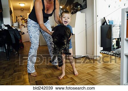 Stock Photo - Mother and son holding pet cat. Fotosearch