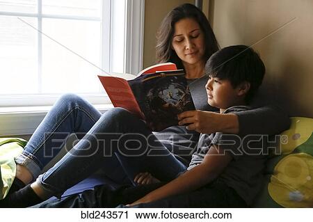 Mother and son reading book near window View Large Photo Image Stock Image - Mother and son reading book near window. Fotosearch