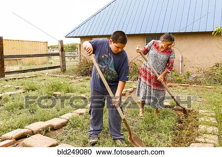 Mother and son shoveling in garden View Large Photo Image Stock Image - Mother and son shoveling in garden. Fotosearch