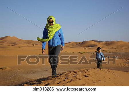 Stock Photograph - Mother and son walking in desert. Fotosearch