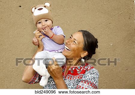 Stock Photograph - Mother carrying baby son on shoulder. Fotosearch