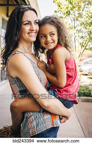 Mother carrying daughter outdoors View Large Photo Image Picture - Mother carrying daughter outdoors. Fotosearch