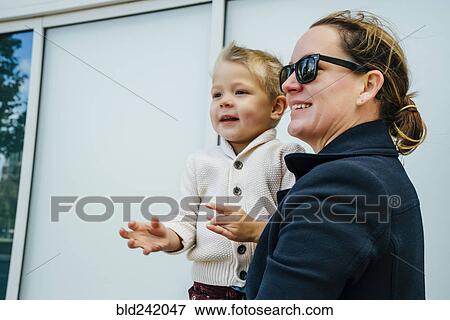 Stock Photo - Mother carrying son outdoors. Fotosearch
