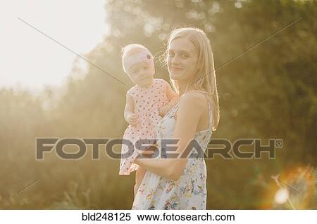 Mother holding baby daughter on sunny day View Large Photo Image Stock Photography - Mother holding baby daughter on sunny day. Fotosearch