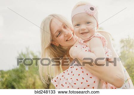 Mother hugging baby daughter on sunny day View Large Photo Image Stock Image - Mother hugging baby daughter on sunny day. Fotosearch