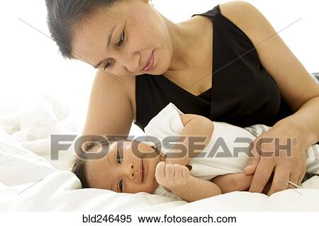 Mother laying on bed with baby son View Large Photo Image Stock Photography - Mother laying on bed with baby son. Fotosearch