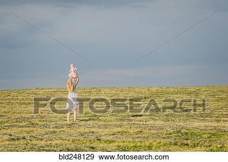 Mother lifting baby daughter in field View Large Photo Image Stock Photo - Mother lifting baby daughter in field. Fotosearch