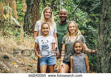 Stock Photography - Multi-ethnic family posing in forest. Fotosearch
