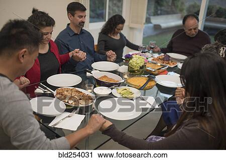 Multi-generation family praying before eating meal View Large Photo Image Stock Image - Multi-generation family praying before eating meal. Fotosearch