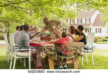 Stock Image - Multi-generation family toasting with lemonade at picnic. Fotosearch