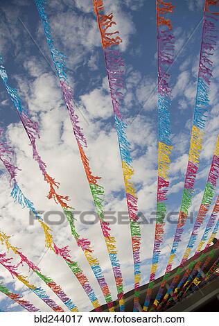 Multicolor flags blowing in wind under blue sky View Large Photo Image Stock Photo - Multicolor flags blowing in wind under blue sky. Fotosearch