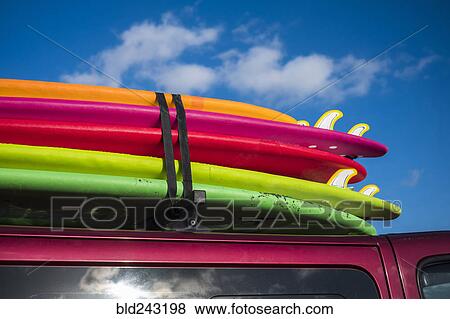 Stock Photo - Multicolor surfboards strapped to roof of car. Fotosearch