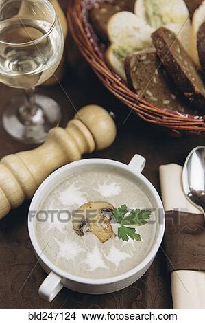 Picture - Mushroom floating in cup of soup. Fotosearch