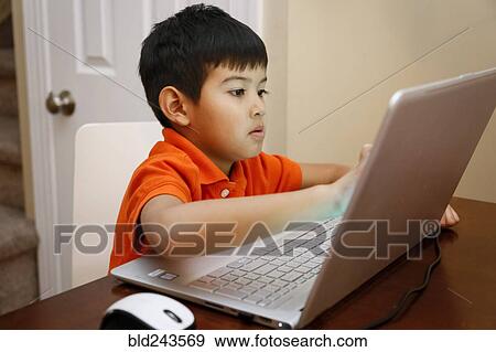 Native American boy sitting at table using laptop View Large Photo Image Stock Photo - Native American boy sitting at table using laptop. Fotosearch